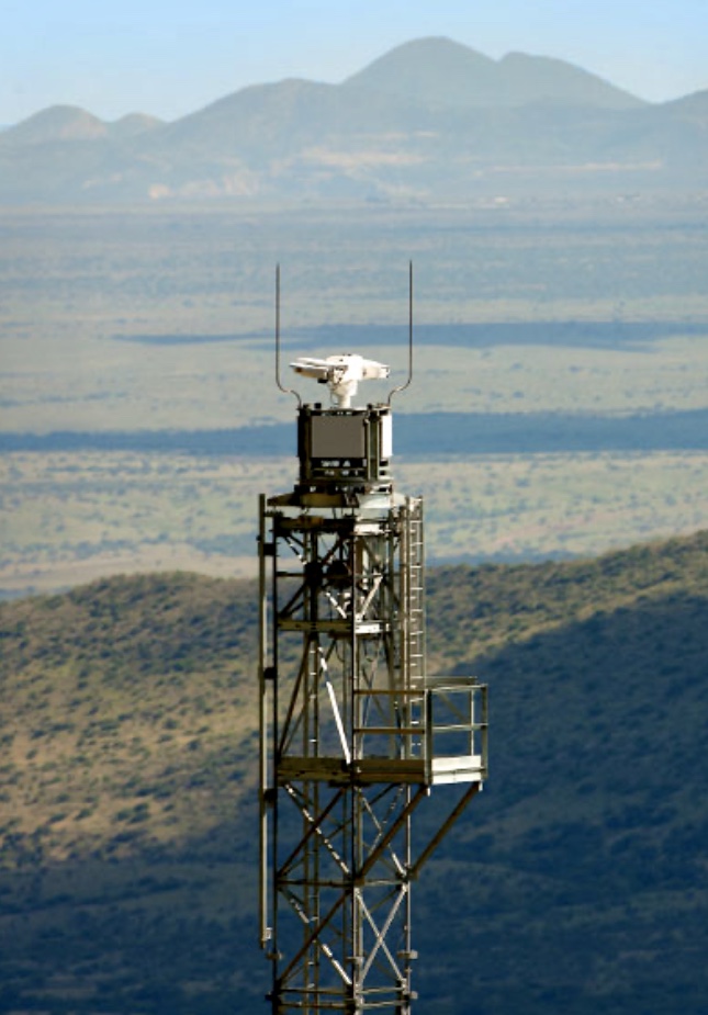 an m9 titanium long range ptz thermal imaging flir camera mounted on a surveillance tower, scanning the horizon for security threats
