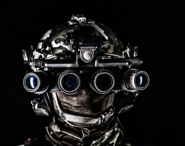 soldier in a modern night vision goggles on black background