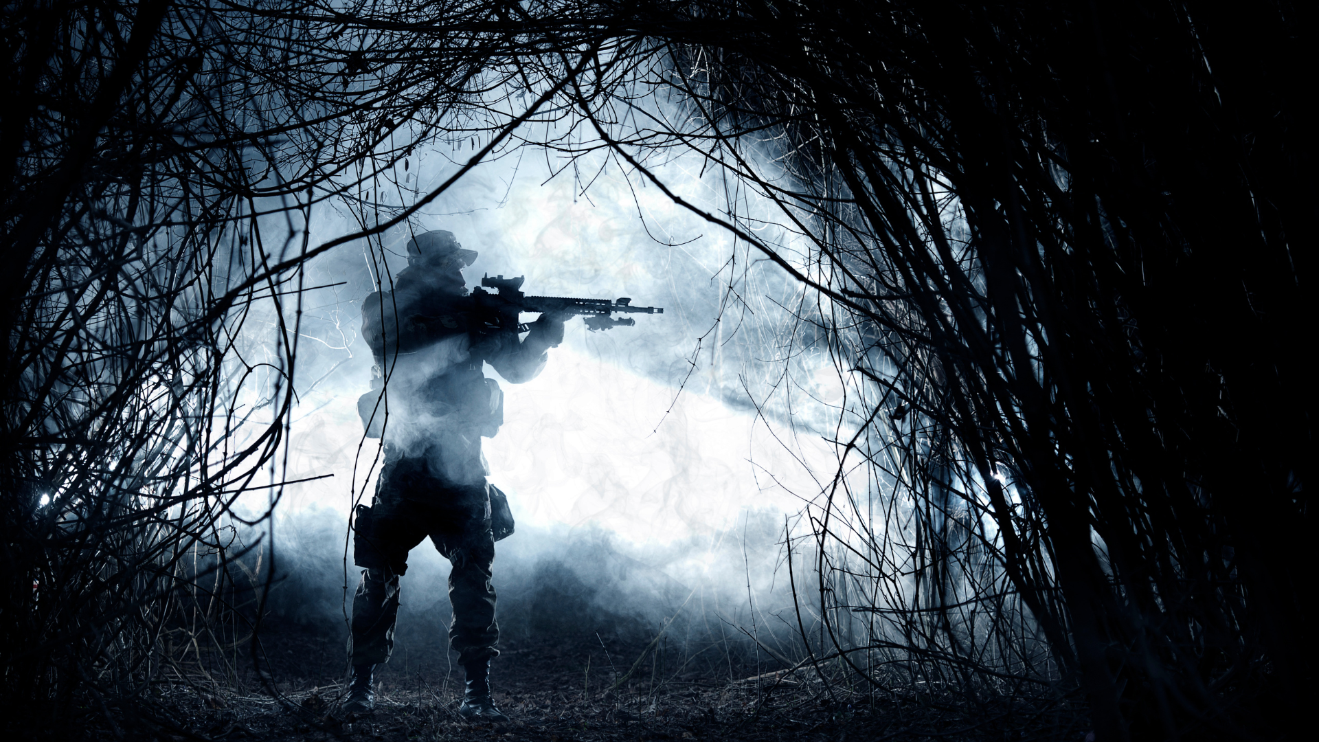 soldier standing at night in woods with weapon