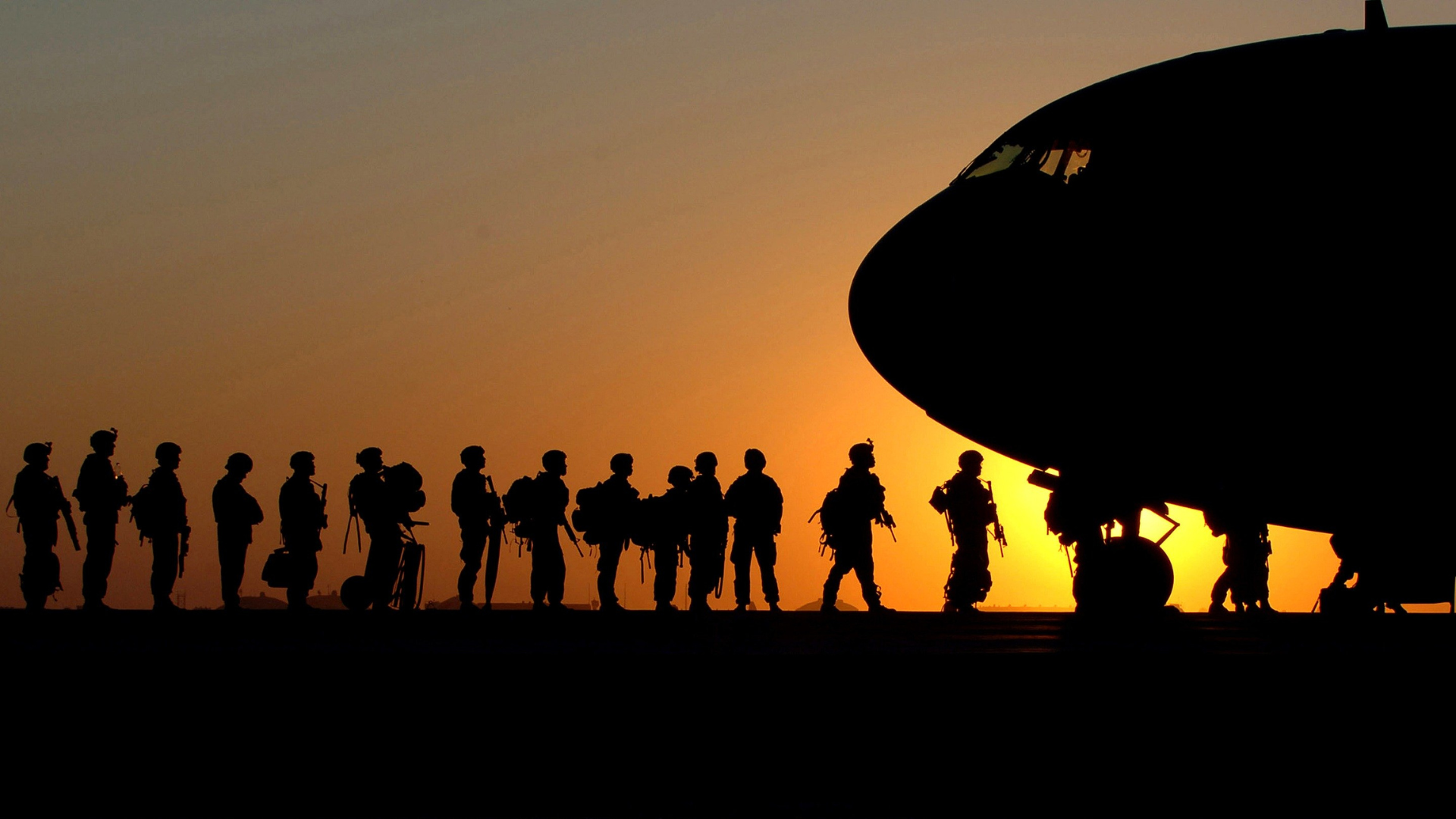 night time soldiers lined up to go in to airplane