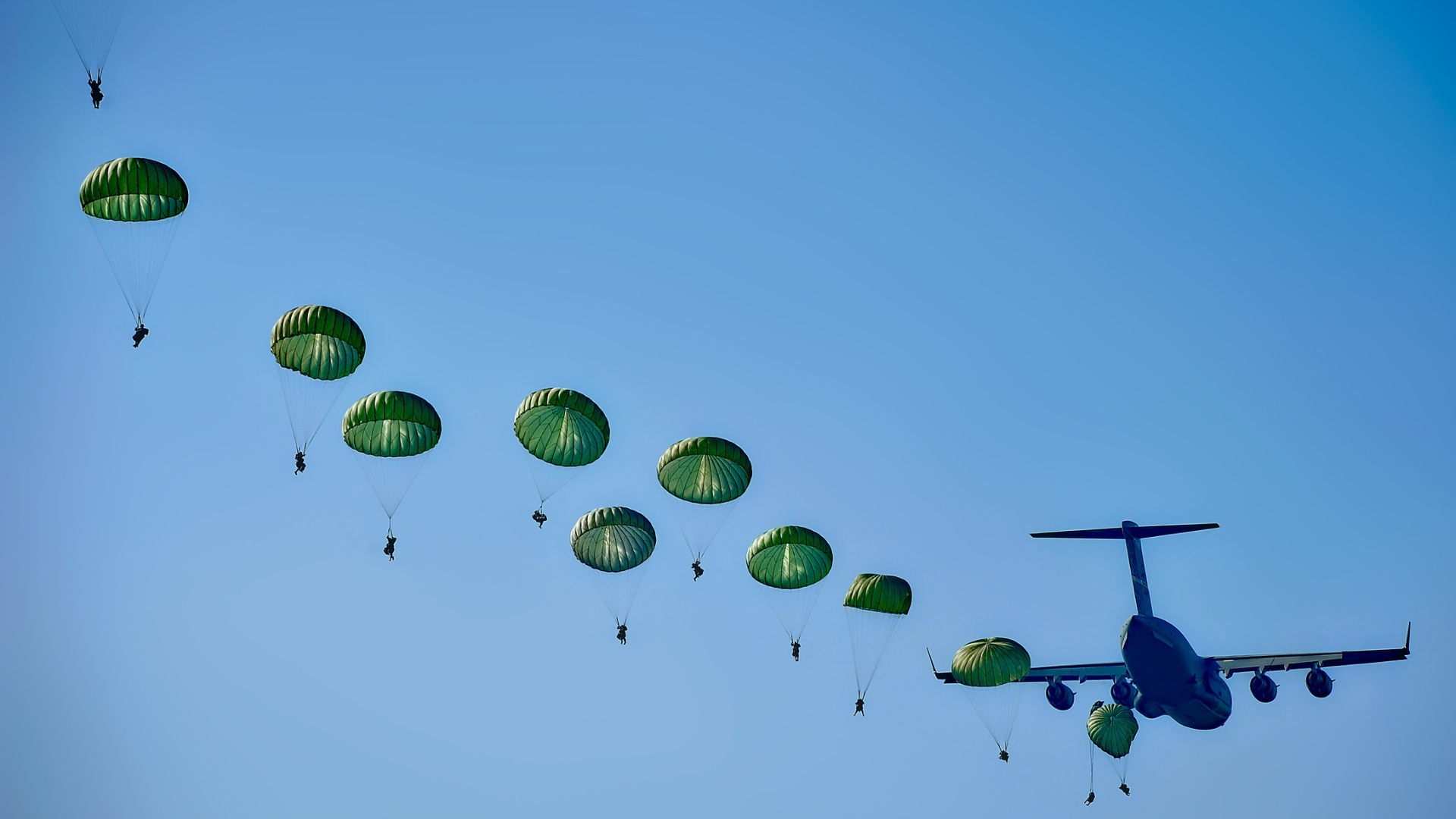 soldiers parachuting out of airplane