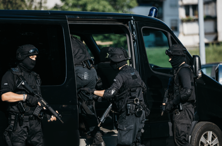 group of men, special forces, armed, standing by van