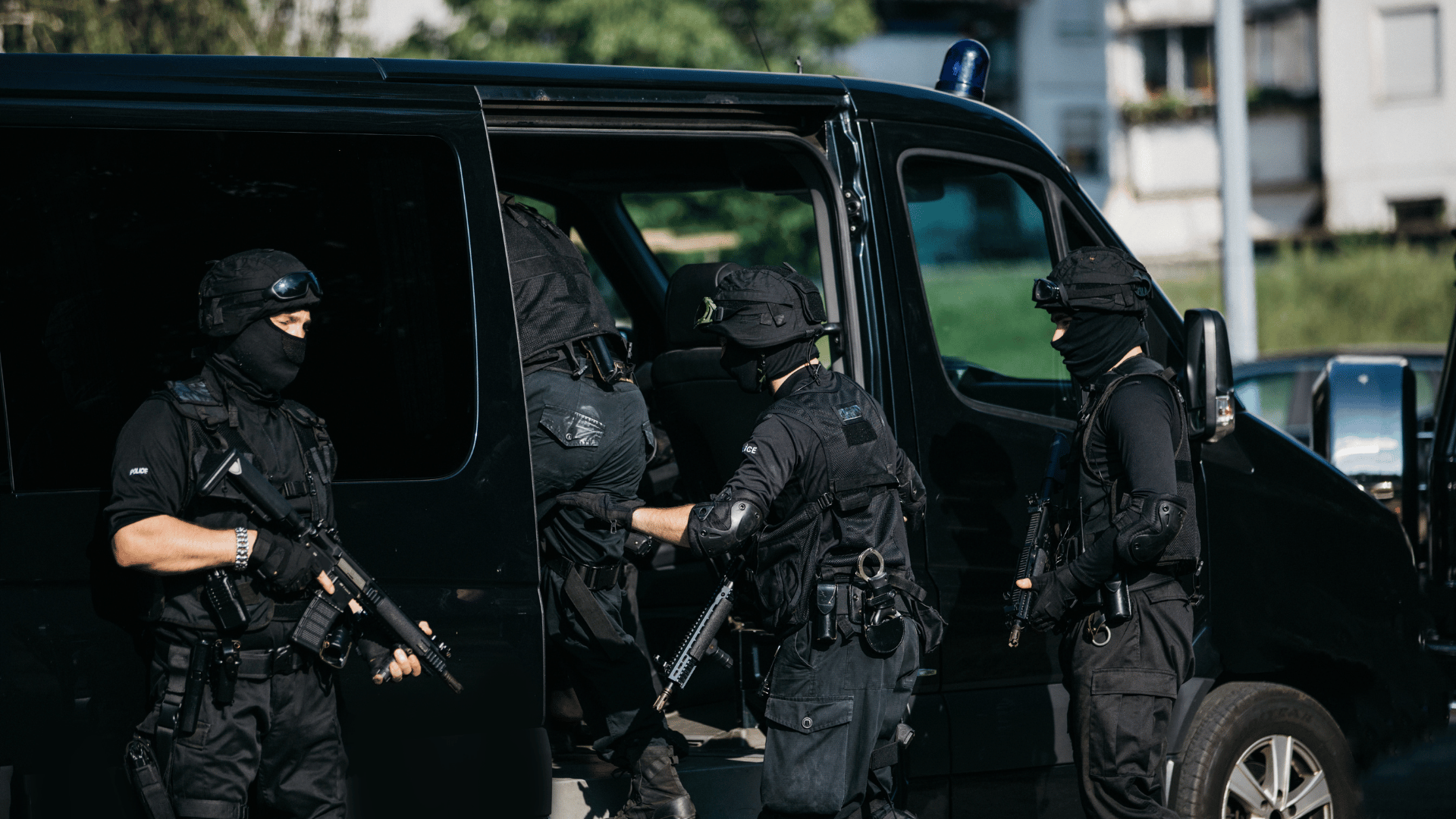 group of men, special forces, armed, standing by van
